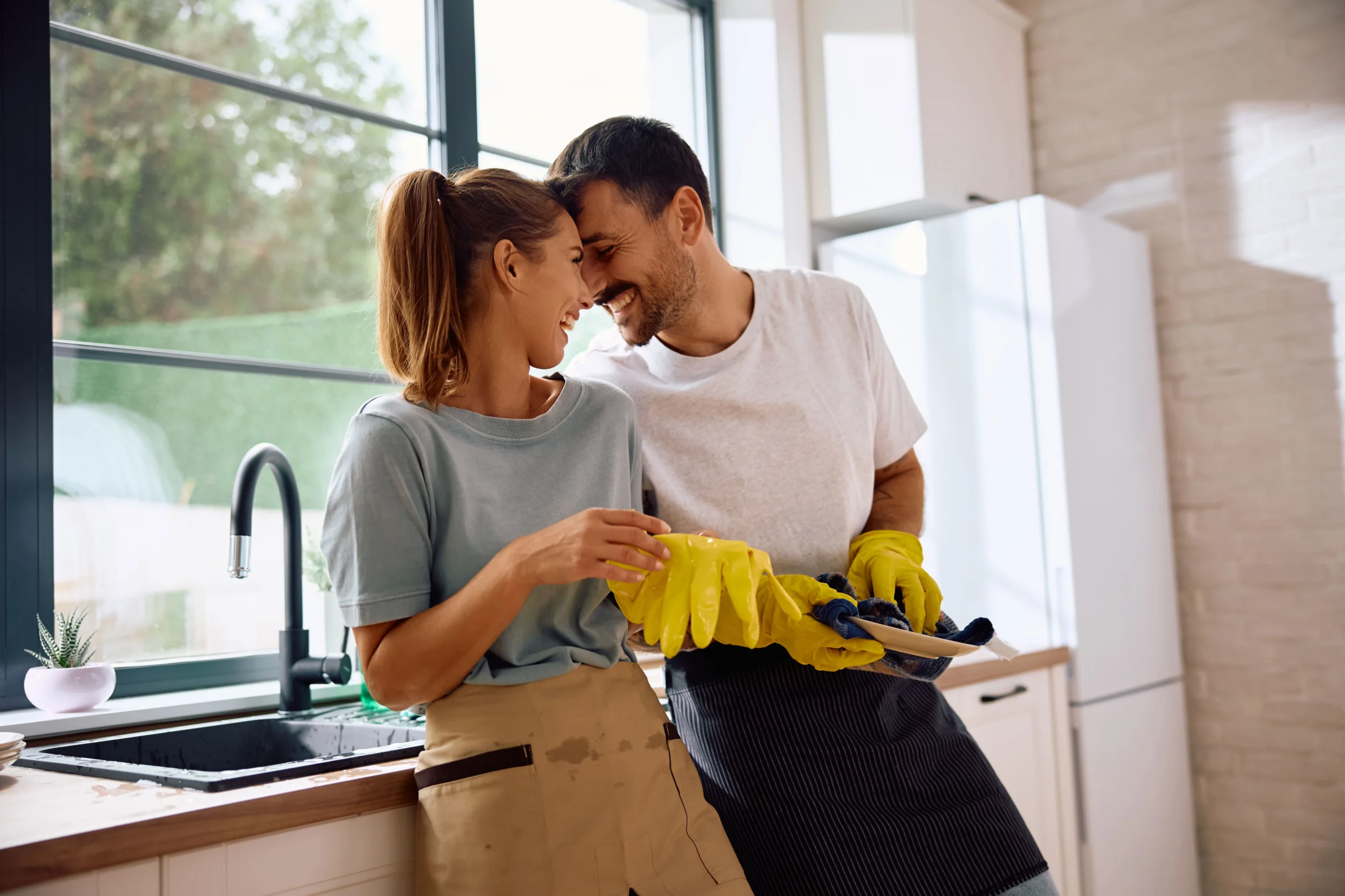 affectionate-couple-doing-dishes-their-kitchen